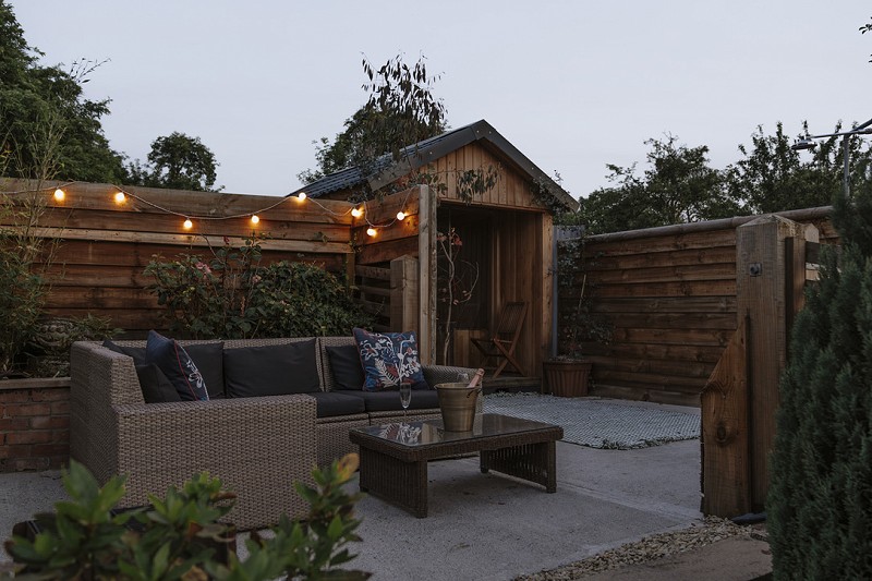 Showing the seating area and outdoor sauna.